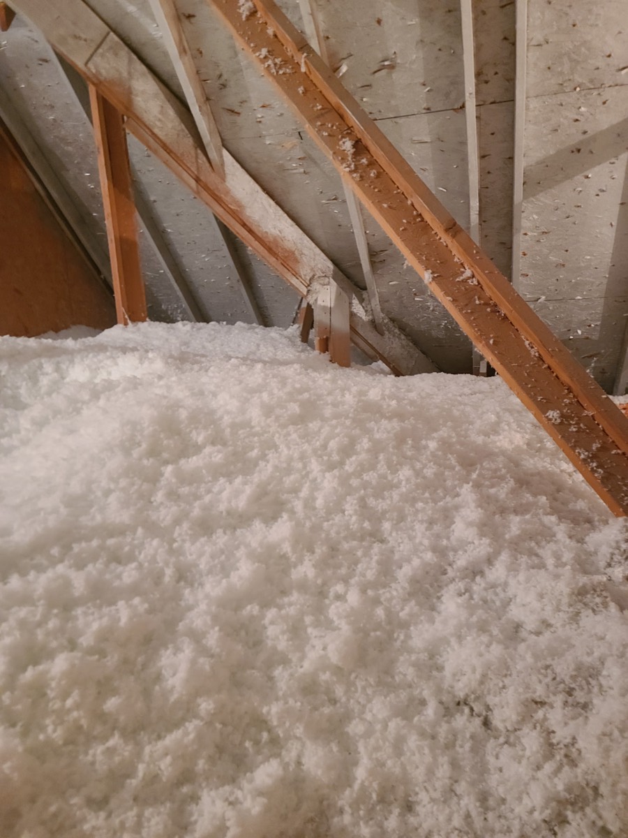 A finished blown-in attic at depth. A top-up ends at this level, whatever it started from.